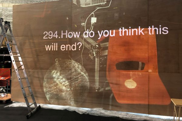 A screen with a photo of a disco ball and an orange chair, with a question overtop that reads '294. How do you think this will end?'