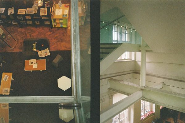 Two photographs cropped together of Manchester Central Library; on the left a person sits reading a newspaper, on the right a corner of stairs