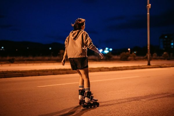 Girl Roller Skating on an empty road at night